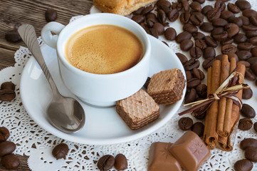 a cup of coffee with coffee beans and cinnamon sticks