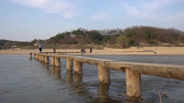 People taking selfies on an old wooden bridge