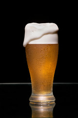 Beer glass with foam with black background