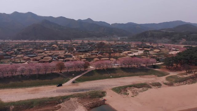 Aerial car tracking with a korean folk villagein the background