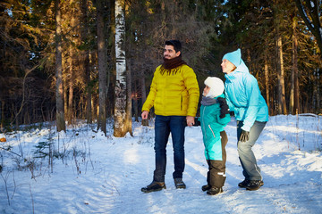 Fototapeta na wymiar Happy family walking in a winter forest
