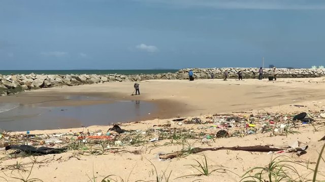 Polluted beach in Rayong with lots of garbage laying around washed out by the ocean, Thailand.