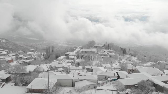Aerial footage over snowy mountain, traditional village in Greece 7