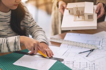 An architect working and cutting papers in office