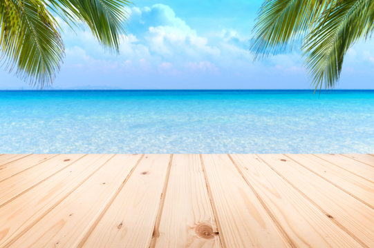 Wooden floor or plank on sand beach in summer. For product display.Calm Sea and Blue Sky Background.