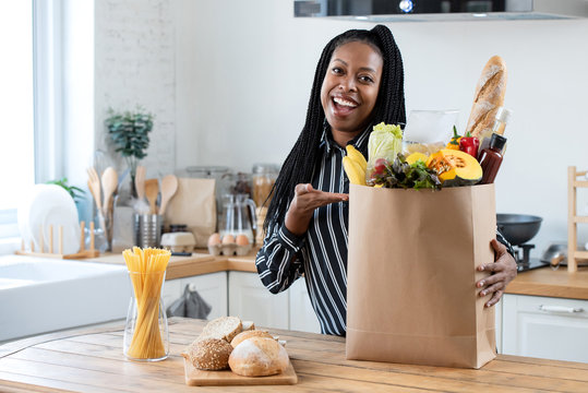 Woman With Grocery Bag In Kitchen