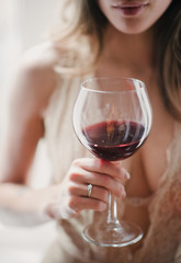 Woman holds a glass with a drink in hand close up