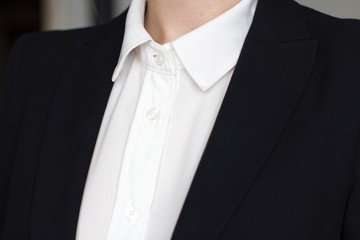 young woman wearing a white shirt and black suit