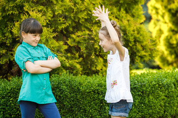 Two cute girls emotionally spend time in the nature. Girls of school age find out relationships....