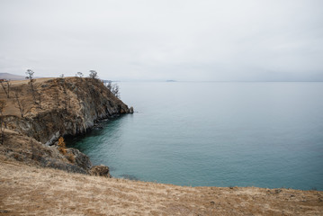 Fototapeta na wymiar cliffs breaking into the blue calm water of a clear lake