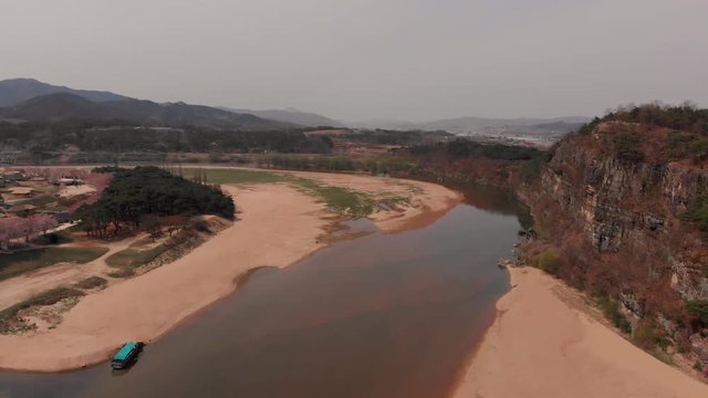 Aerial reveal traditional asian village by a river and a cliff
