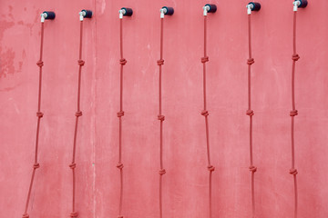 Red climbing wall with long ropes.