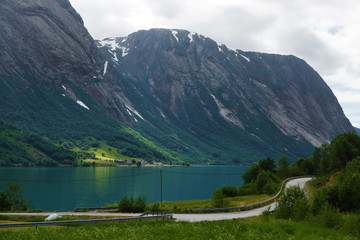 Travel to Norway, the blue mountain river flows among the mountains, along the coast there is a road
