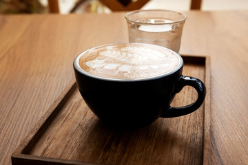 Hot latte with beautiful latte art on the wooden table