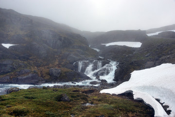 Travel to Norway, the river flows from the mountain, where there is still snow in June
