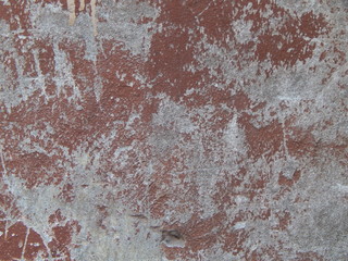 The old concrete floor or wall, long painted with brown paint, which has already peeled off, a rough interesting background