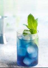 Blue lagoon, Tropical cocktail served with ice cubes decorated with mint. Refreshing alcohol drink for party at summer.