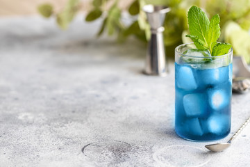 Blue lagoon, Tropical cocktail served with ice cubes decorated with mint. Refreshing alcohol drink for party at summer.