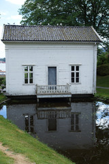 Fototapeta na wymiar Travel to Norway, a small white house is reflected in the pond
