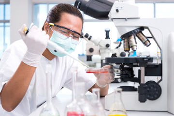 Serious clinician studying chemical element on tester