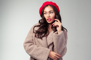 Attractive young woman in red beret and fashionable coat