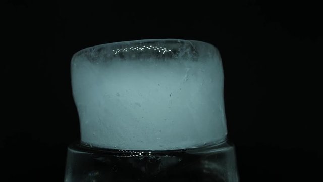 Closeup studio time lapse shot of a large piece of ice melting.