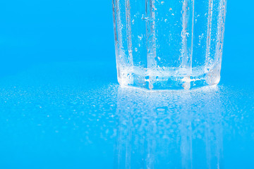 Naklejka na ściany i meble glass of water on a blue background