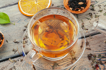 Cup of tea and tea leaves on wooden table