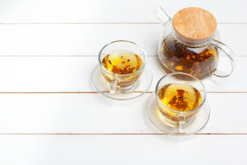 teapot and cups of tea on a white wooden background