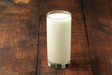 A glass with milk on a wooden rustic table