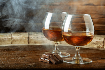 Two glasses of bourbon or scotch, or brandy and pieces of dark chocolate