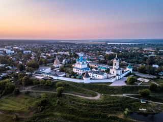 Obraz premium Aerial view of the ancient Orthodox Christian monastery, located among the houses and nature in the city of Serpukhov. Early summer morning. Moscow region