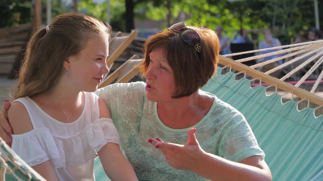 Intimate talk heart-to-heart between grandmother and granddaughter teenager girl telling her secrets and mature womat gives an advice