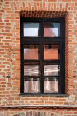  Architecture details. Beautiful window in the brick palace castle. The reflection in the glass of the sky and buildings  