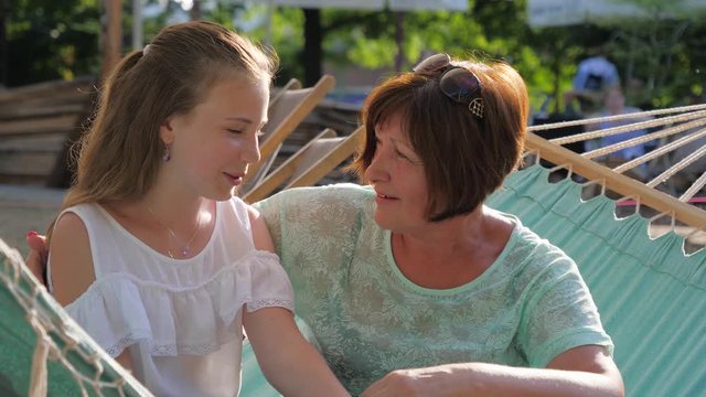 Intimate talk heart-to-heart between grandmother and granddaughter teenager girl telling her secrets and mature womat gives an advice