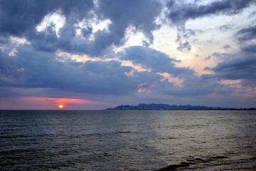 Scenic sunset over the sandy beach in Golem / Durres, Albania. Sunset sky at Adriatic sea with Durres town silhouette. 