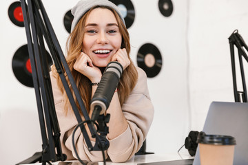 Beautiful happy young female radio host broadcasting