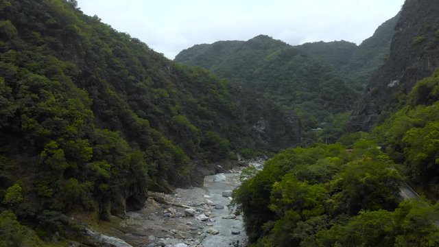 AERIAL - Drone Rises Over River Gorge In Asia With Mountains Cars Rivers Bridge