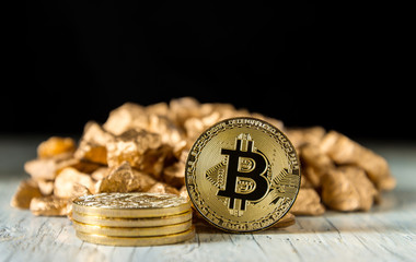 Golden Bitcoin Coin and mound of gold on a dark background.