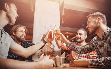 Meet friends of men in beer bar, happy smiles on your face. Concept celebration victory of sports...