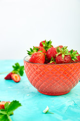 Ripe red strawberries on blue table, Strawberries in red bowl. Fresh strawberries. Beautiful strawberries. Diet food. Healthy, vegan. Close up