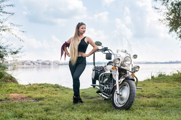 Fototapeta na wymiar Beautiful woman posing with helmet and motorcycle