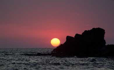 Sunrise over the forehead of the rock. View from Sinemorets resort, Southern Black Sea Coast, Bulgaria.