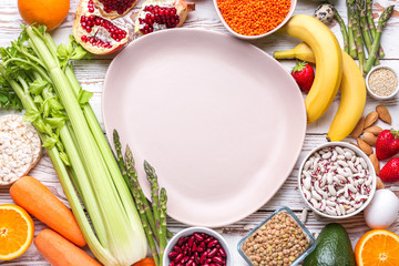 Different healthy food with plate on white wooden table