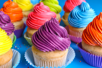 Sweet tasty cupcakes on color background