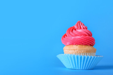 Sweet tasty cupcake on color background