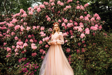 mysterious lady in light gentle dress walks through flowered garden, young beautiful girl walks in...