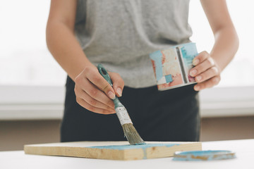 painting furniture, close-up hand with brush