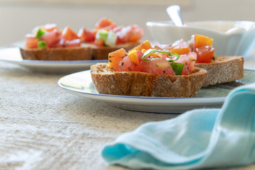Close up view of tasty tomato Italian appetizers -  bruschetta, on slices of toasted baguette