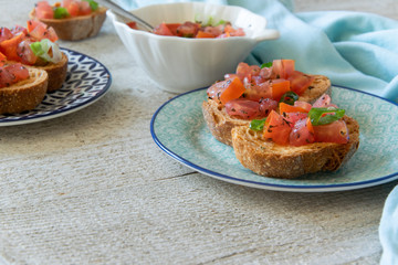 Close up view of tasty tomato Italian appetizers -  bruschetta, on slices of toasted baguette